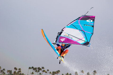 Fanatic FreeWave TE windsurf board during wave riding with aerial maneuver at a tropical coastline