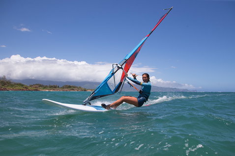 Fanatic Gecko HRS freeride windsurf board during windsurfing on turquoise ocean water near a tropical coastline