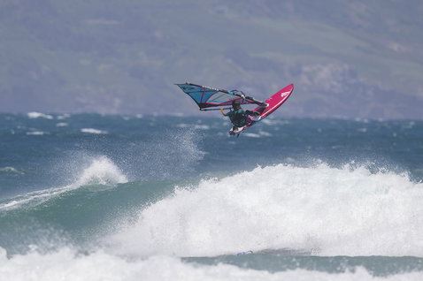 Fanatic Grip XS Wellenboard 60L in pink beim Windsurfen über einer Welle im Meer