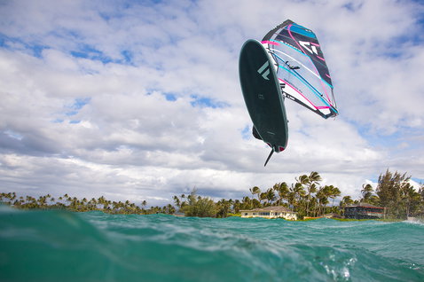 Fanatic Jag LTD Windsurfboard beim Freestyle-Sprung über dem türkisfarbenen Meer vor tropischer Küste