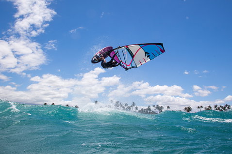Planche de windsurf freestyle Fanatic Skate TE lors d'un trick aérien au-dessus de l'océan tropical