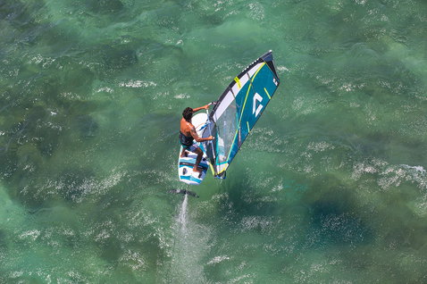 Fanatic Stingray HRS Foil Windsurfboard beim Foilen auf türkisem Ozean aus der Vogelperspektive