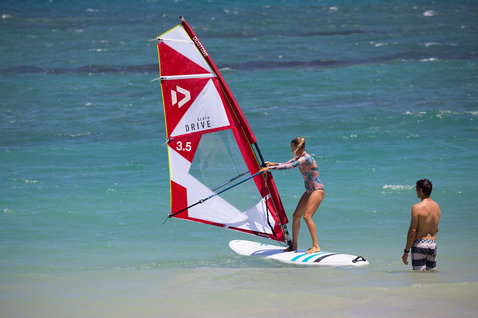 Fanatic Viper windsurf board during windsurfing lesson in shallow turquoise ocean on a sunny beach