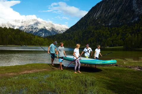 Fanatic Fly Air XL aufblasbares SUP Board beim Paddeln am Bergsee mit Gruppe