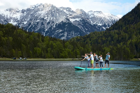 Duotone Fly Air XL aufblasbares SUP Board beim Stand-Up-Paddeln mit Gruppe auf einem Bergsee