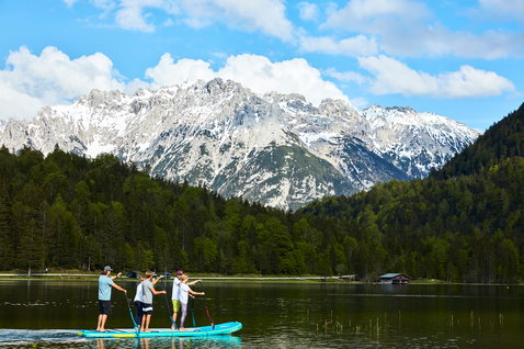 Duotone Fly Air XL aufblasbares SUP Board mit fünf Personen beim Stand Up Paddling auf einem Bergsee