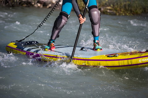 Fanatic Rapid Air Touring inflatable SUP board during river paddling in yellow and purple