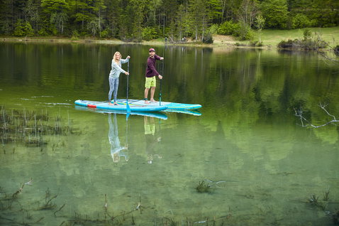 Duotone Ray Air inflatable touring SUP board during stand-up paddling on an alpine lake