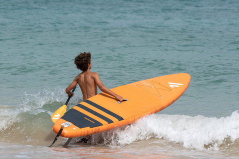 Fanatic Ripper Air Touring inflatable kids SUP 10'0" in orange during stand-up paddling at the ocean