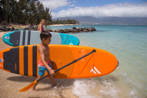 Planche SUP gonflable enfant Fanatic Ripper Air Windsurf en orange lors d'une session SUP sur la plage