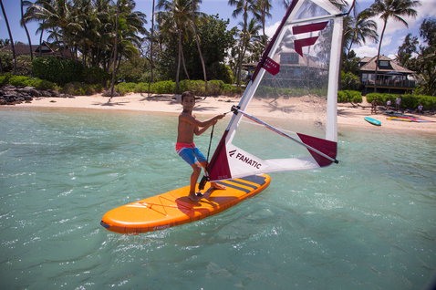 Planche de windsurf gonflable enfant Duotone Ripper Air 187 cm en orange lors du windsurf dans un lagon tropical