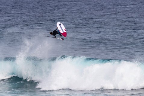 Duotone ProWave LTD SUP wave board during wave riding with aerial above a breaking ocean wave