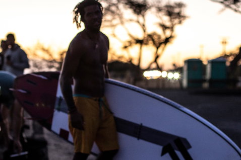 Duotone SUP ProWave LTD wave board carried by athlete at golden hour on the beach