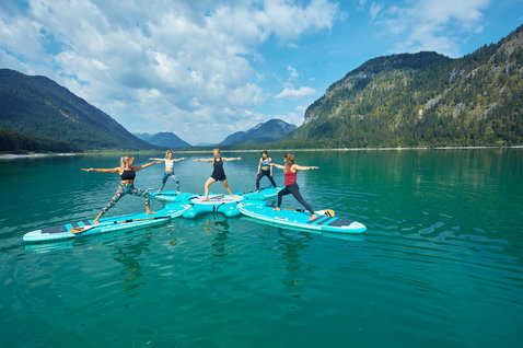Duotone Fly Air Fit Platform during SUP yoga with 5 participants on a turquoise alpine lake