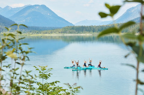 Duotone SUP Fly Air Fit Platform during SUP yoga class with four people on an alpine lake