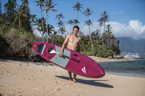 Duotone Blitz Carbon SUP Rennsboard in tief magenta beim Stand Up Paddling am Tropenstrand