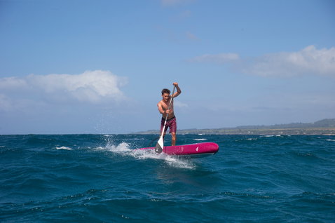 Duotone SUP Falcon Carbon Race-Board beim SUP-Racing auf dem offenen Ozean in magenta und weiß