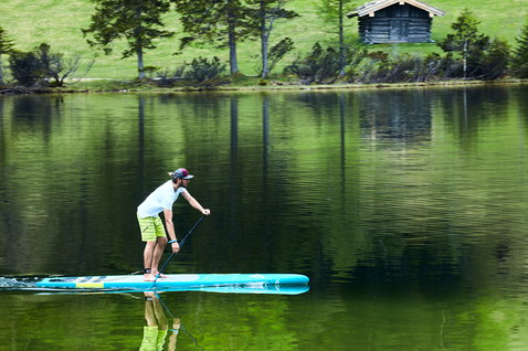 Duotone Ray LTD touring SUP board during stand up paddling on an alpine lake in teal