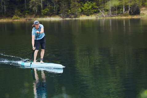 Duotone SUP Ray Pure Light touring SUP board 12'6" in light blue during paddling on a mountain lake