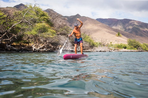 Planche de course SUP Duotone Strike Carbon lors d'une course SUP sur eau plate avec montagnes