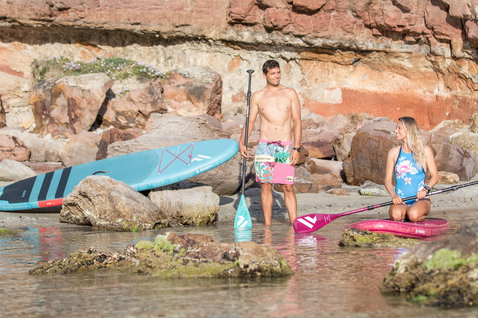 Duotone SUP Carbon 25 adjustable 3-piece paddle during stand-up paddleboarding at a rocky coastal beach