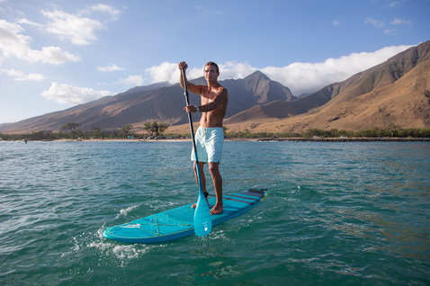 Duotone Carbon 35 verstellbares 3-teiliges SUP-Paddel beim Stand Up Paddling an einer Küste mit Bergen