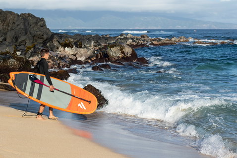 Duotone Carbon 80 adjustable 3-piece SUP paddle during stand up paddling at a rocky ocean beach