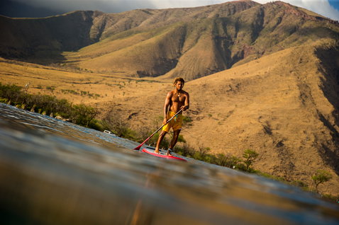 Duotone Stubby Air Premium inflatable SUP board during stand-up paddling at the coast in golden-hour light