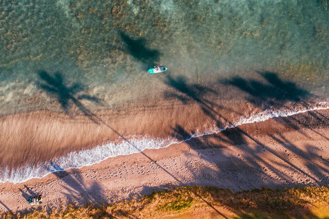 Duotone Fly Air aufblasbares SUP-Board beim Paddeln im flachen Wasser an einem tropischen Strand in Maui