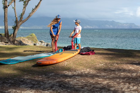 Duotone Ripper Air planche de windsurf SUP gonflable 187 cm en orange lors de la mise à l'eau en bord de mer