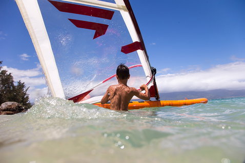 Planche de windsurf gonflable enfant Duotone Ripper Air 187 cm en orange lors d'une session de windsurf en mer