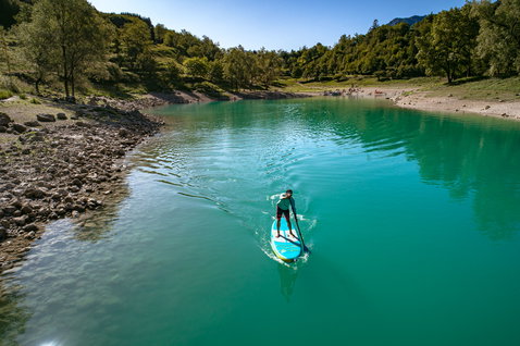 Duotone SUP Fly Air Pocket aufblasbares SUP Board 10'4" beim Paddeln auf einem türkisen Bergsee