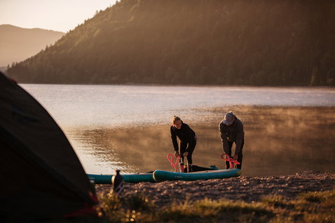 Fanatic Ray Air Pocket aufblasbares Touring SUP Board beim Aufpumpen an einem Bergsee im Abendlicht