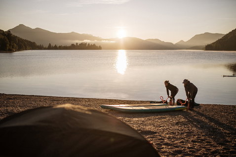 Fanatic Ray Air Pocket aufblasbares Touring SUP Board beim Vorbereiten am Bergsee im goldenen Abendlicht