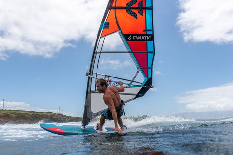 Fanatic FreeWave TE windsurf board during wave riding on the ocean in teal and coral