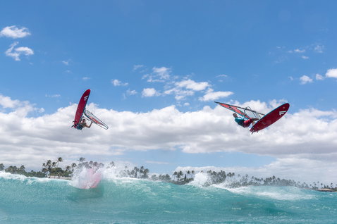 Fanatic FreeWave TE windsurf board during wave windsurfing with two riders airborne over tropical ocean waves