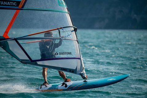 Planche de windsurf freeride Fanatic Gecko LTD 115L en bleu turquoise lors d'une session de windsurf sur le lac de Garde