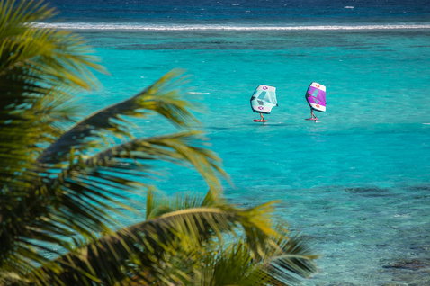Fanatic Sky Air Premium inflatable foil board during wing foiling in a turquoise tropical lagoon