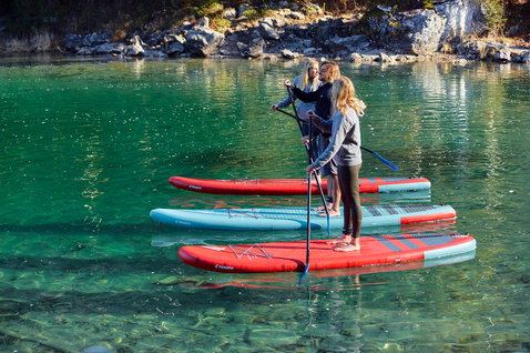 Fanatic Fly Air inflatable SUP board during stand up paddling on a turquoise mountain lake