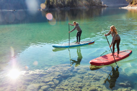 Fanatic Fly Air inflatable SUP board during stand up paddling on a turquoise alpine lake