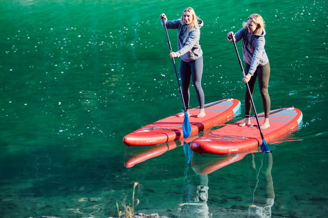 Duotone SUP Ray Air Pure aufblasbares Touring SUP Board beim Stand Up Paddling auf einem Bergsee