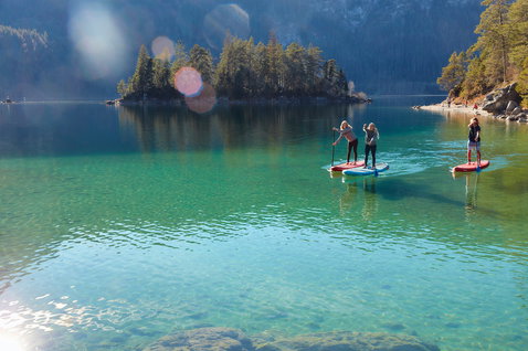 Duotone Ray Air Pure aufblasbares Touring-SUP beim Stand-Up-Paddeln auf einem türkisblauen Bergsee
