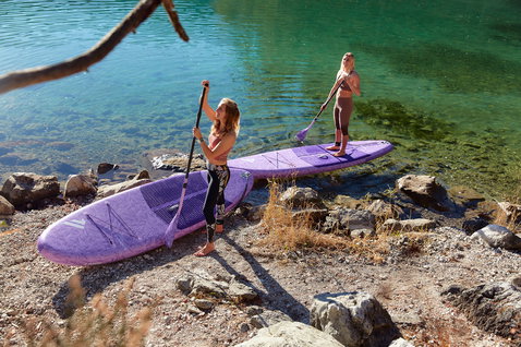 Duotone Diamond Air Pocket inflatable SUP board 10'4" in purple during stand-up paddling on a mountain lake