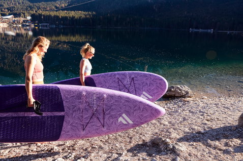 Duotone Diamond Air Touring Pocket inflatable SUP board 11'6" in purple during touring at an alpine lake