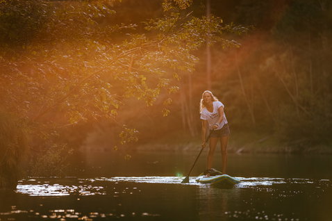 Fanatic Ray Air Enduro Premium paddle gonflable lors d'une session de stand-up paddle sur une rivière au coucher du soleil