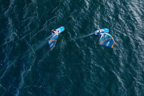 Fanatic Stingray LTD foil windsurf board during wind foiling on the ocean — aerial view with two riders