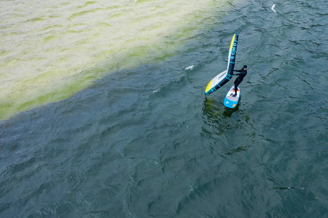 Fanatic Stingray LTD foil board during wing foiling on open water, aerial drone shot