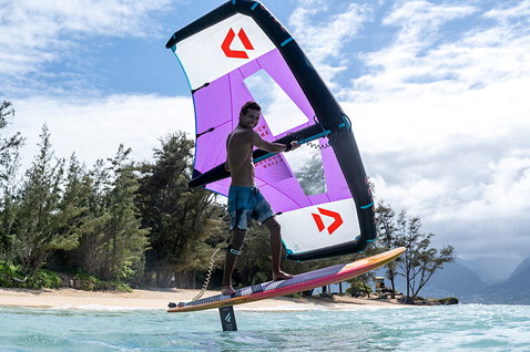Fanatic Aero wing set during wing foiling at a tropical beach in purple and black