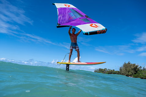 Fanatic Flow set d'aile avant de foil en wing foiling au-dessus de l'océan en violet, blanc et orange
