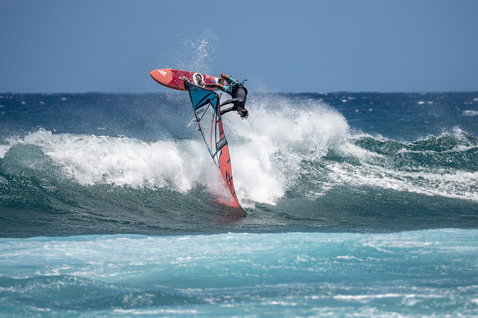 Fanatic Grip TE wave windsurf board during wave riding on the ocean with aerial maneuver